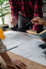 The home design architects are reviewing the house plan draft, the project commissioned by the...