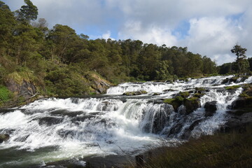River flowing with green hills and blue sky