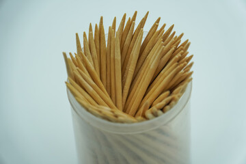 Wooden toothpicks and holder on white background, flat lay. Space for text