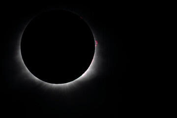 Solar eclipse at totality showing corona and solar flares