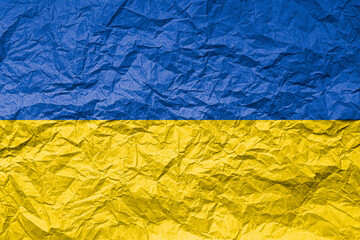 Flag of Ukraine on crumpled paper. Textured background.