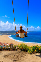 Person on a swing enjoying beautiful beach and atlantic ocean- Portugal