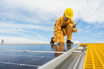 Engineers check the installation of solar panels on the factory roof, command engineers, supervise...