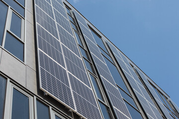 Fototapeta na wymiar Modern building with solar panels on the wall, facade.