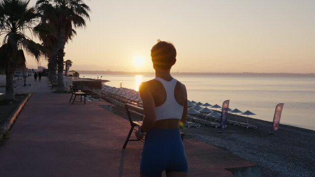 Running, caucasian woman and fitness on sunrise, blue sky for exercise goals, energy and power. Happy athlete, cardio and outdoor workout with motivation, smile and wellness.