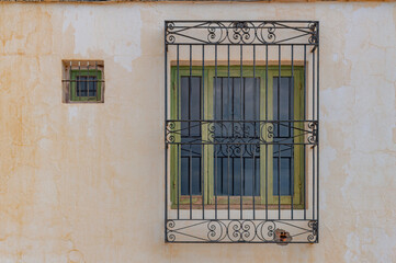 Window with iron bars on white wall