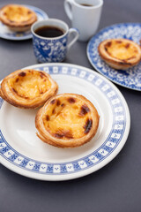 Portugal's traditional sweet dessert Pastel de nata egg custard tart pastry,  with coffee on a table in a street cafe