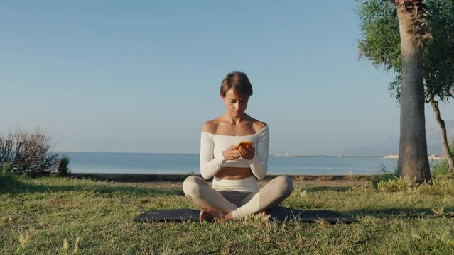 Caucasian woman practicing yoga at seashore of tropic ocean. 