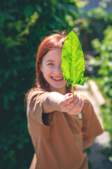 Cute girl holding a sorrel leaf in her hand. healthy food, greens, health care, vitamins, diet