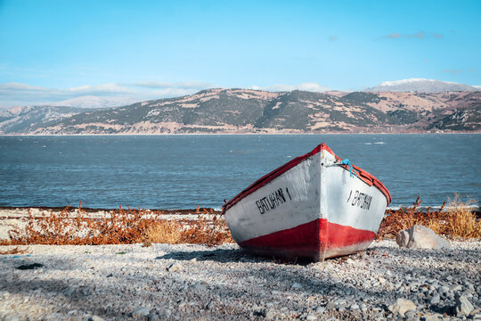 Abandoned boat on the shore of Egirdir lake with mountains in the distance and copy space - Isparta Region, Turkey 2022