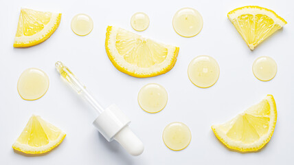 Drops of cosmetic serum and lemon slices. White background. Skin care product
