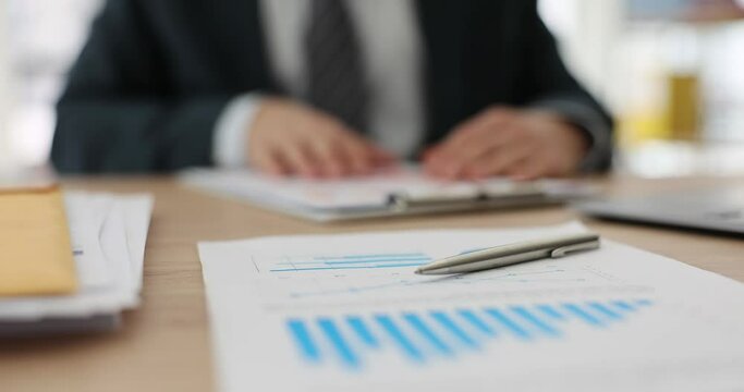 On the table of a business man, a report with a diagram and a pen, a close-up. Analysis and result of the company