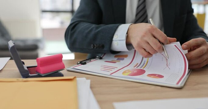 A business man is watching reports in the folder, close-up. Coordination of documents of the company