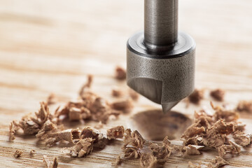 Countersink drill bit with steel triangle ruler make sink in hole for screw in wooden oak plank - obrazy, fototapety, plakaty
