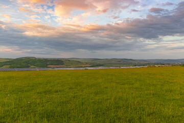 Rural landscape photography with grain fields and meadows, taken in the summer, on cloudy weather, at sunset. 