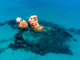 View from the drone. Splendid view of the beach of Cea with the Rocce Rosse, the Scogli Rossi - Faraglioni. White sand and crystal clear water. Tortoli, Ogliastra, Sardinia, Italy