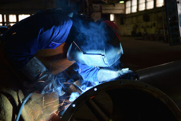 A factory worker making a weld