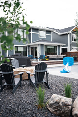 Backyard landscaping with rocks firepit chairs and pool 