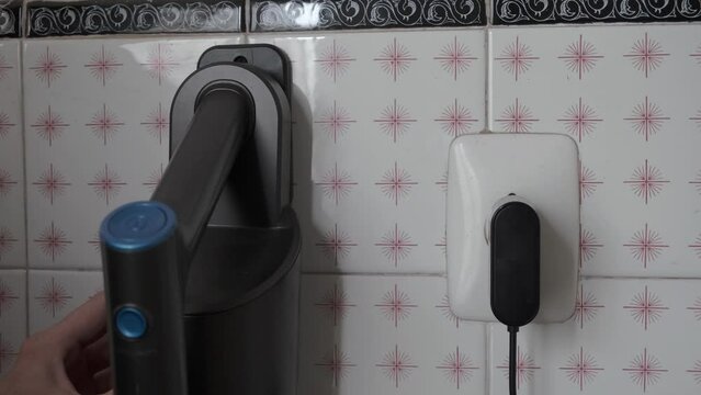 hand connecting to the european power outlet an electrical appliance
