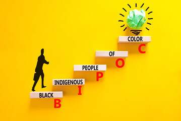 BIPOC black indigenous people of color symbol. Concept words BIPOC black indigenous people of color on wood block. Beautiful yellow background. Business BIPOC black indigenous people of color concept.