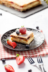 A piece of Napoleon cake with poppy seeds and cherries