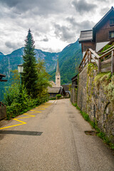 Famous Hallstatt city panorama with typical church near the Hallstatter see. Dramatic clouds on the sky. Famous tourist destination in Austria.