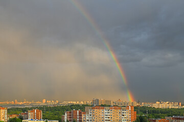 Heavenly landscape with rainbow, rain and sunlight over Moscow city. Russia