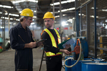 Group of male engineer worker discuss and checking oil tank in factory. Team of male technician inspecting quality in plant during manufacturing process