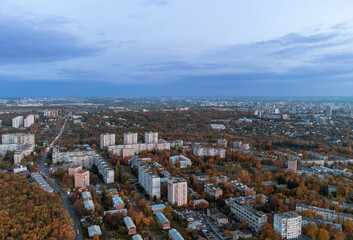 Aerial autumn evening city view. Residential district with park and dark blue cloudy sky. Kharkiv, Ukraine