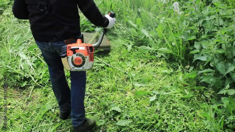 Poster man mowing grass with a trimmer