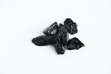 Black shiny decorative stones on white background. Natural obsidian.