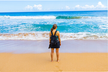Female Tourist on The Sandy Shore of  Kauapea Beach, Kauai, Hawaii, USA