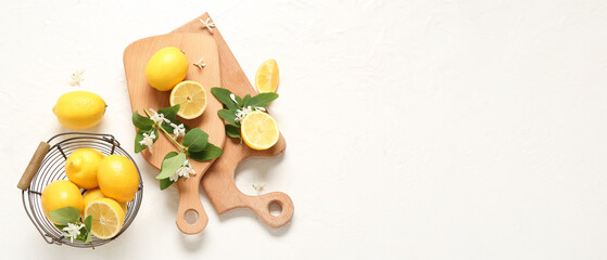 Composition with lemons and blooming branches on white background with space for text, top view
