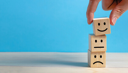 Customer Experience Concept. The best rating. Hand holding smile face or happy face on wooden cube block.