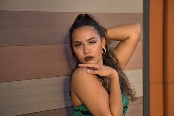 Latin and Hispanic girl, young and beautiful, with green eyes and large eyelashes, looking at the camera in a sensual and provocative attitude. Concept beauty, fashion, provocation, sensuality.