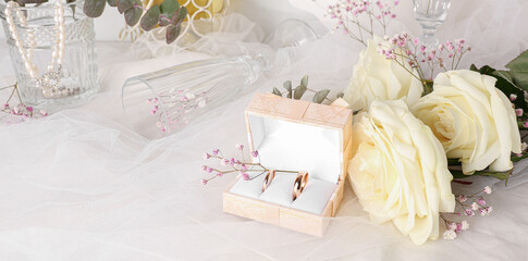 Box with wedding rings and flowers on veil