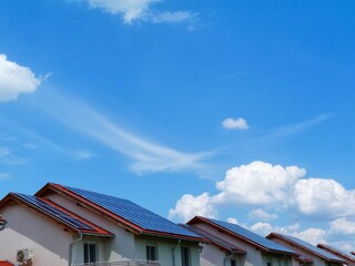 roof installed photovoltaic PV sun collector solar panels. sloped clay residential roofs. blue sky...