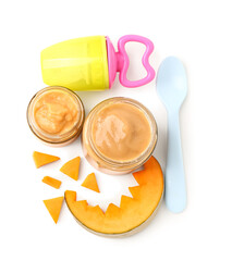 Jars of baby food, pumpkin and nibbler on white background