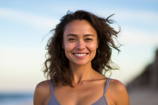 Portrait of a beautiful young woman smiling at the camera on the beach