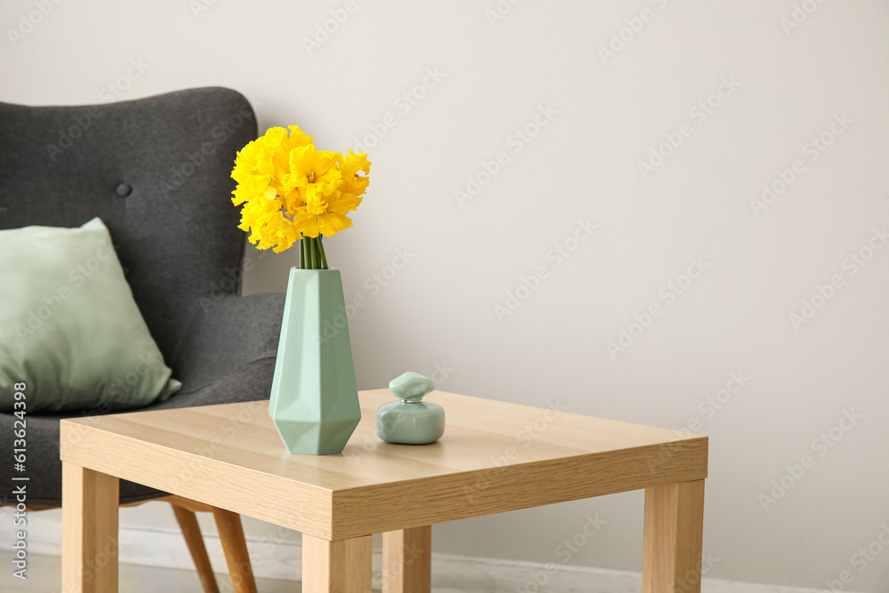 Poster Vase with narcissus flowers and perfume on table in living room