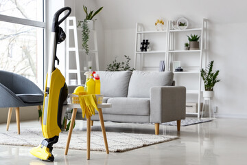 Table with cleaning supplies and hoover in living room
