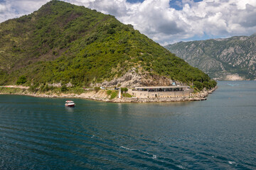 Fototapeta premium Landscape Exposure done from a cruise ship, showing the sea entrance to Kotor bay and its beautiful coastal landscapes and small villages , on a sunshiny day.