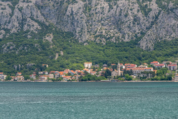 Landscape Exposure done from a cruise ship, showing the sea entrance to Kotor bay and its beautiful coastal landscapes and small villages , on a sunshiny day.