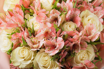A large bouquet of pink alstroemerias and white roses. Selective focus.