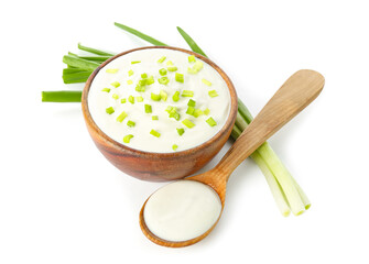 Bowl and spoon of tasty sour cream with green onion on white background