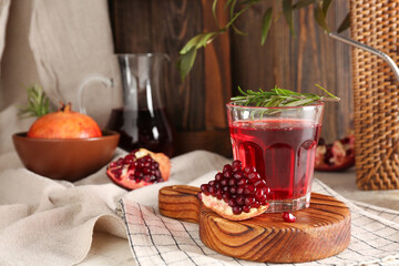 Bowl with fresh pomegranate and glass of juice on white table