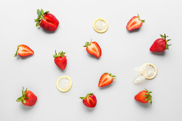 Strawberries with condoms on light background. Sex concept