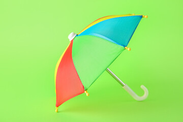 Mini colorful umbrella on green background