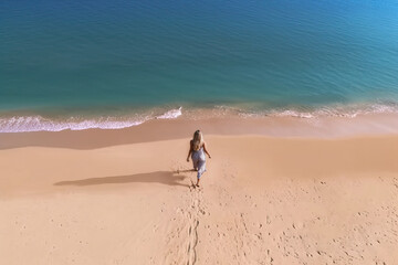 Fototapeta na wymiar Photo of a woman taking a walk by the ocean on a serene beach