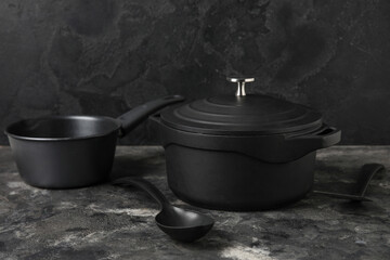 Cooking pots and spoon on dark background